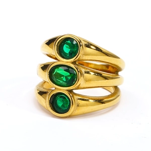 Detail of three-layer gold-plated rings featuring oval emerald green zircon gemstones