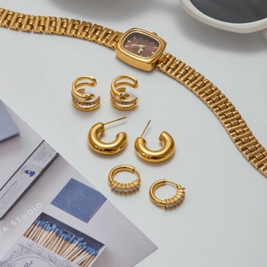 Three-piece gold stainless steel earring set with snake ear cuffs and huggie hoops