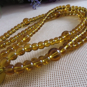 Close-up of amber beaded strap with large honey yellow resin beads and small accents