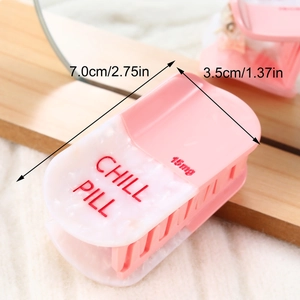 Detail view of pink and marble acetate hair claw in pill shape with Chill Pill text