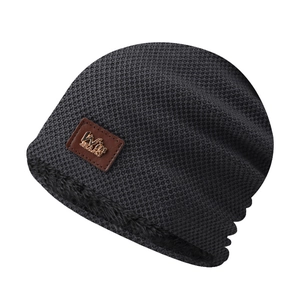 Detail of grey winter knit beanie with thick fleece lining and leather logo patch