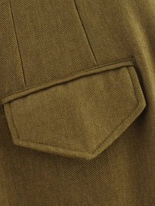 Close-up of olive green twill fabric showing fine stitching detail on jacket pocket