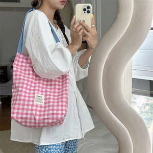 Selfie miroir d'un sac cabas en toile à carreaux roses avec anses bleues et étiquette