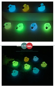 Micro landscape luminous resin ducks in blue, yellow, and green glowing in the dark