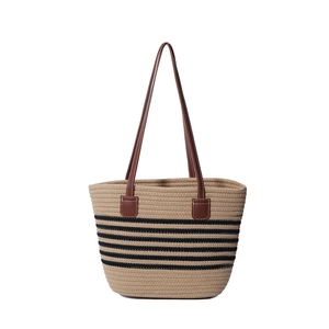 Borsa tote in paglia intrecciata a righe nere con manici in pelle marrone su sfondo bianco