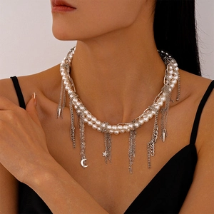 Detail of layered pearl necklace featuring silver moon and star pendants with tassels