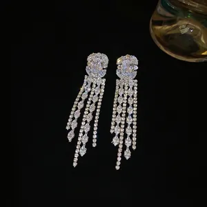 Silver drop earrings with square zircon stones and long dangling tassels on black background