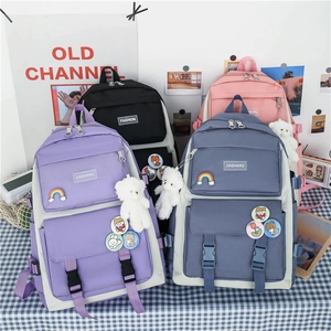 Detail showing student backpacks in purple, black, pink, and blue with cute bear charms