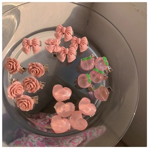 Detailed view of pink resin hair clips featuring matte bows and 3D floral camellia shapes