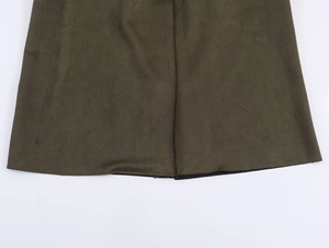 Détail d'un manteau en daim vert olive montrant les coutures de l'ourlet et la texture