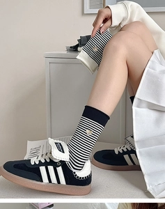 Nahaufnahme von schwarz-weiß gestreiften Baumwollsocken mit goldener Bärenbestickung