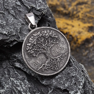 Vintage silver Tree of Life pendant made of titanium steel on dark natural rock