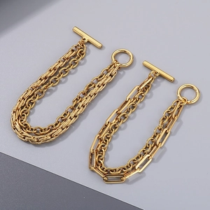 Detail of gold Cuban link and paperclip chains with OT buckle on a bicolor background