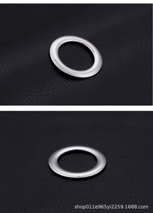 Macro detail of polished 18k gold plated round ring pendants on black leather texture