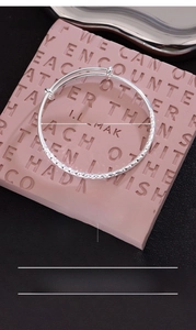 Detail view of 60mm hammered silver plated bangle with diamond cut geometric texture