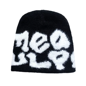 Détail du bonnet en maille épaisse Mea Culpa montrant la texture douce et les lettres blanches