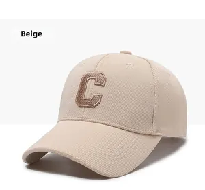 Close-up of beige baseball cap featuring a premium 3D embroidered letter C on textured fabric