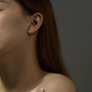 Detailed close-up of a 925 sterling silver gold stud earring on a model's ear