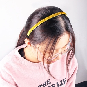 Sparkly gold glitter headband for kids with non-slip fabric on a young girl model