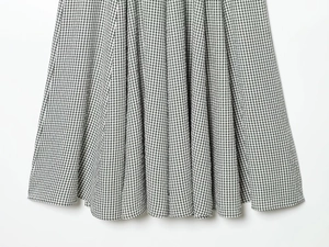 Détail de tissu vichy noir et blanc montrant des plis souples et un tissage texturé