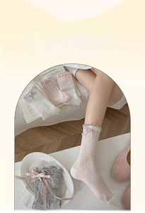 Dettaglio di calze in cotone con fiocco rosa con pizzo e trama a coste