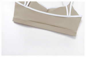 Macro shot of double-stitched contrast white piping on tan yoga sports bra straps