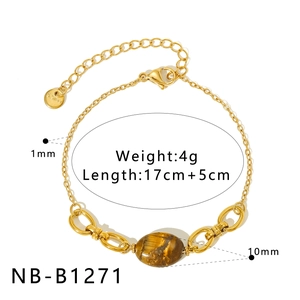 Detail of gold stainless steel bracelet featuring an oval tiger eye stone charm with clasp