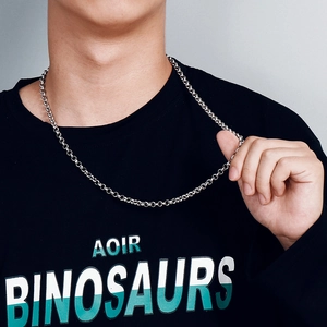 Close-up of minimalist silver stainless steel chain necklace on model wearing a black t-shirt