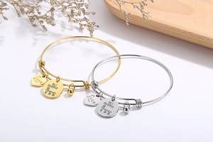 Detail of adjustable gold and silver bracelets with Love and Mi Mama heart charms