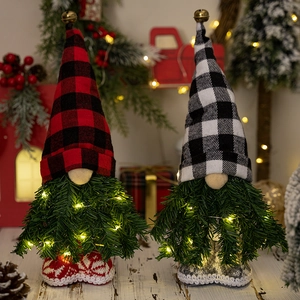 Gnomi di peluche natalizi illuminati con barbe di aghi di pino e cappelli a quadri.