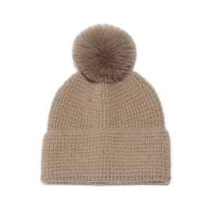Detailed close-up of taupe knit beanie with waffle texture and large faux fur pom-pom