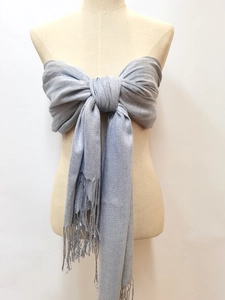 Detail of silver glitter shawl with tassels styled as a tube top on a mannequin