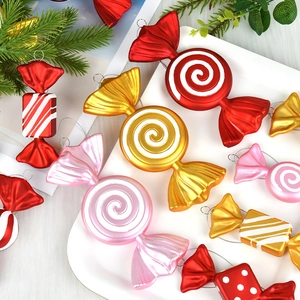 Colorful PVC candy-shaped Christmas tree ornaments with spirals and stripes in a tray