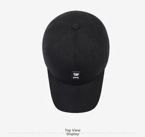 Top view of a black winter baseball cap with ear flaps and TUTUMN LUCK patch