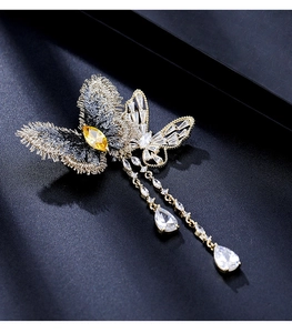 Détail de la broche papillon en zircon avec broderie dorée et chaînes à pampilles