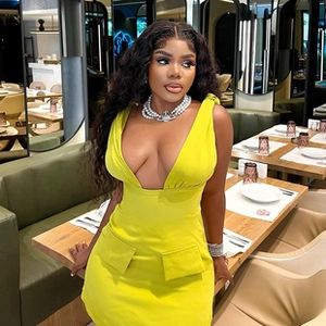 Detailed view of neon green deep V-neck dress fabric and elegant pearl necklace