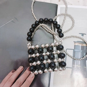 Detail of handcrafted mini beaded bag with black and silver metallic round beads