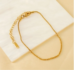 Close-up of gold-plated stainless steel anklet showing S.STEEL tag and lobster clasp