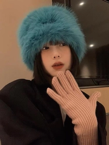 Detail of blue faux fur bucket hat and pink knitted gloves for winter warmth and protection