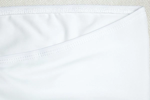 Close-up of white elastic knit fabric showing high-quality stitching and texture details