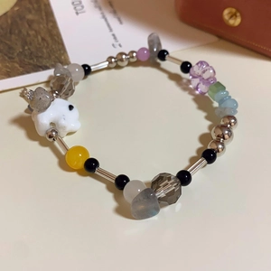 Detail of handmade ceramic rabbit bracelet with multicolor beads and silver tube accents