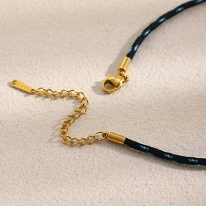 Detailed macro view of 18K gold plated lobster clasp and S.STEEL stamp on woven necklace