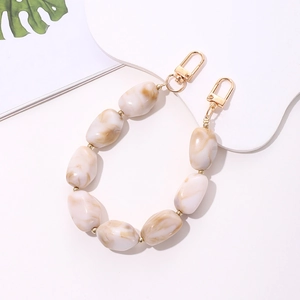 Detail of beige marble acrylic beaded chain with gold metal buckles for bags