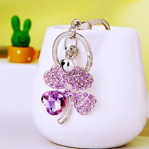 Silver metal four-leaf clover keychain with purple heart crystal and bell accessory