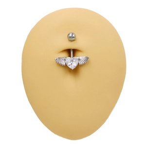 Piercing de nombril avec pierre en cœur et ailes argentées sur un mannequin en silicone