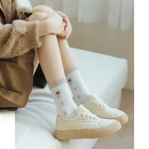 Detail of breathable white cotton socks with cute bear embroidery and pink trim