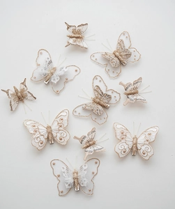 Close-up of elegant champagne lace butterfly hair clips with pearls and sequins