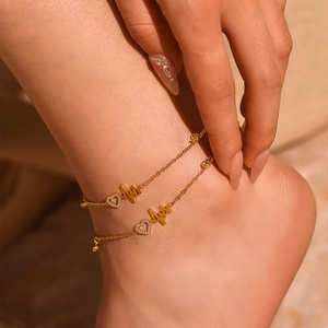 Gold layered anklet with sparkling heart and heartbeat line pendant on ankle