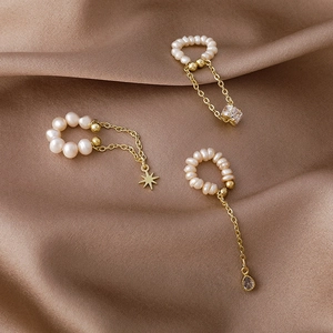 Detail of freshwater pearl ear cuffs with tassel chains and zircon charms on silk