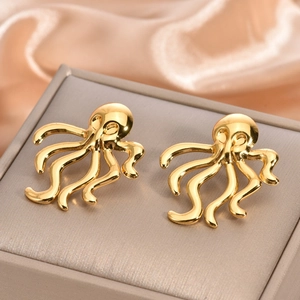 Macro shot of gold octopus stud earrings with polished tentacles on a jewelry box